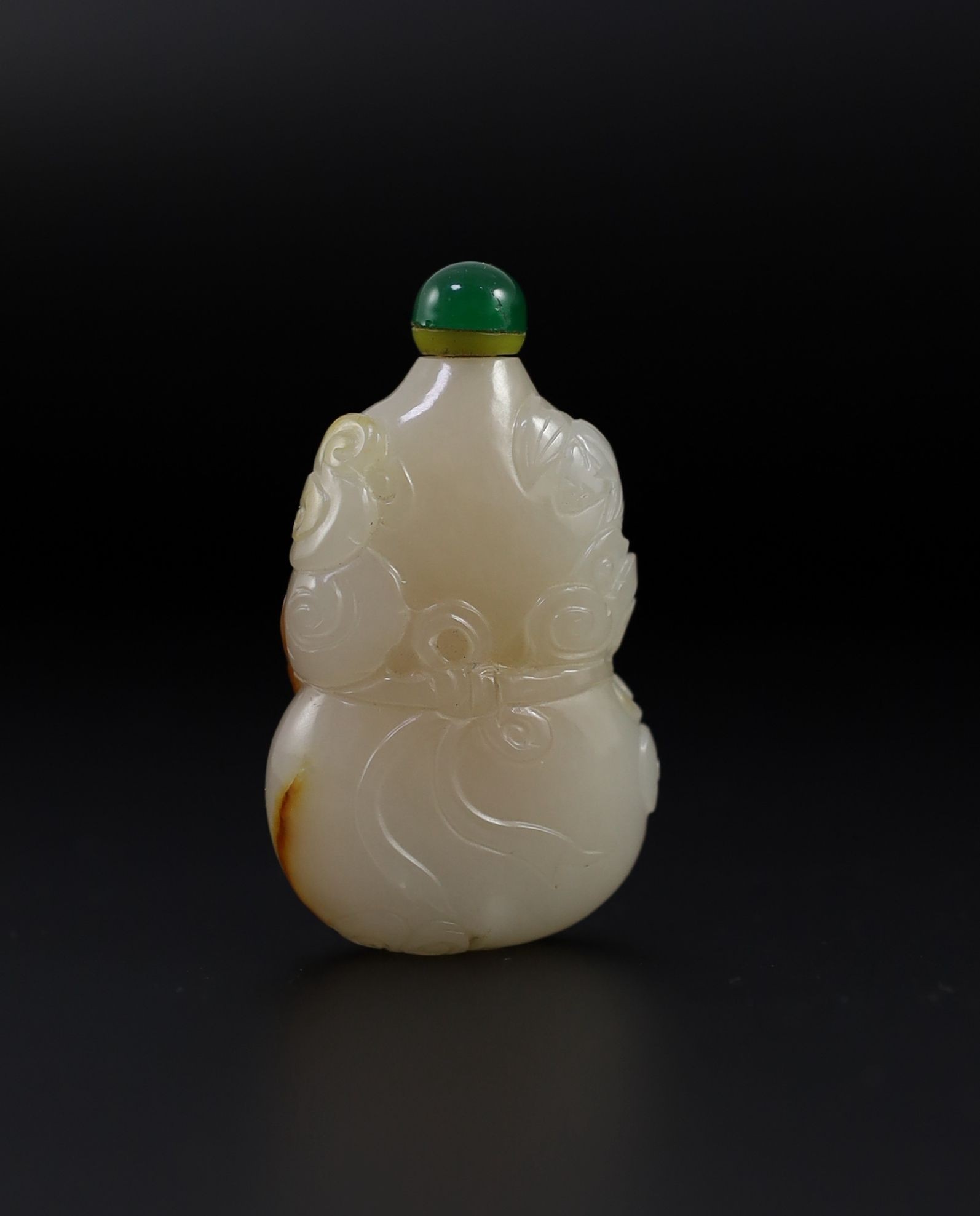 A Chinese white and russet jade snuff bottle, 19th century, 4.9 cm high excluding stopper